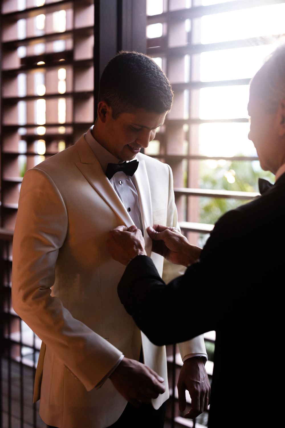 A person in a white dress shirt stands near a window adjusting clothing in a series of silhouetted images.