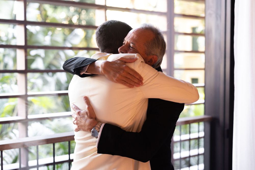 Two figures dance in an intimate embrace on an outdoor balcony or patio area with railing visible in the background.