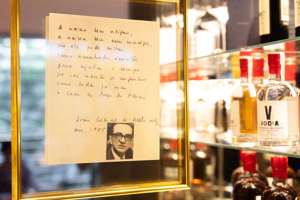 Notes and photographs adorn a wall display in what appears to be a gallery or memorial setting.