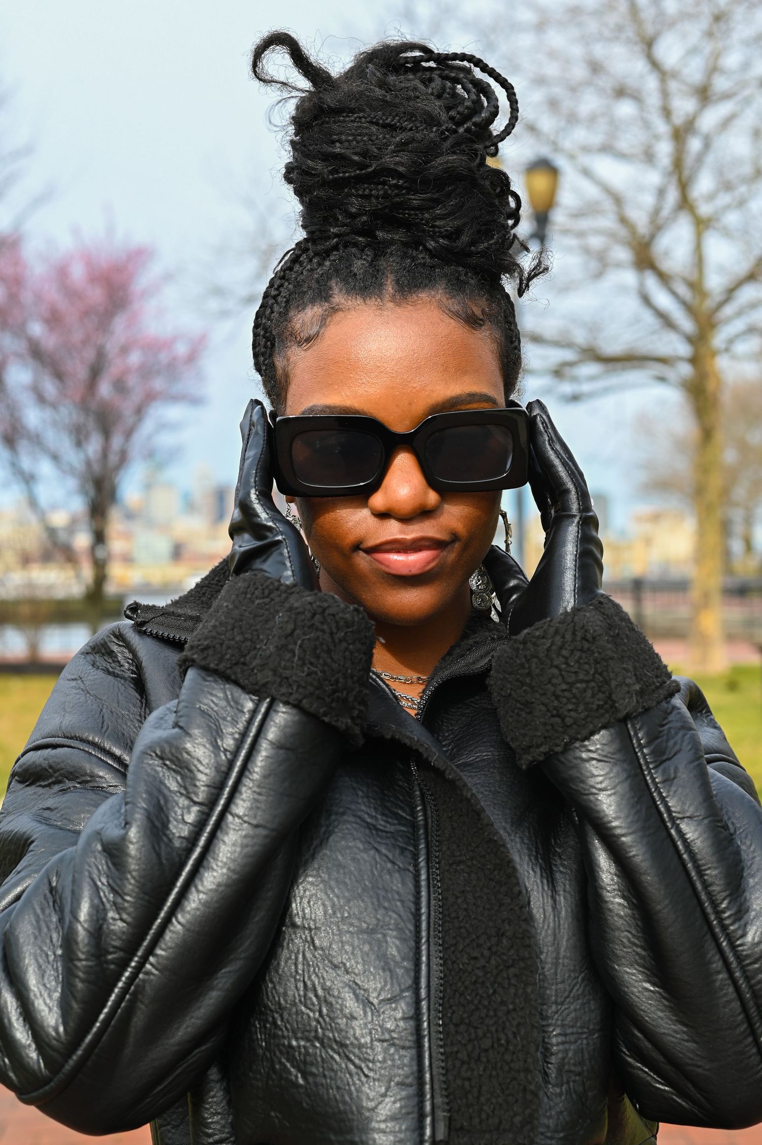 A winter fashion look with black puffer jacket, sunglasses and statement updo hairstyle.