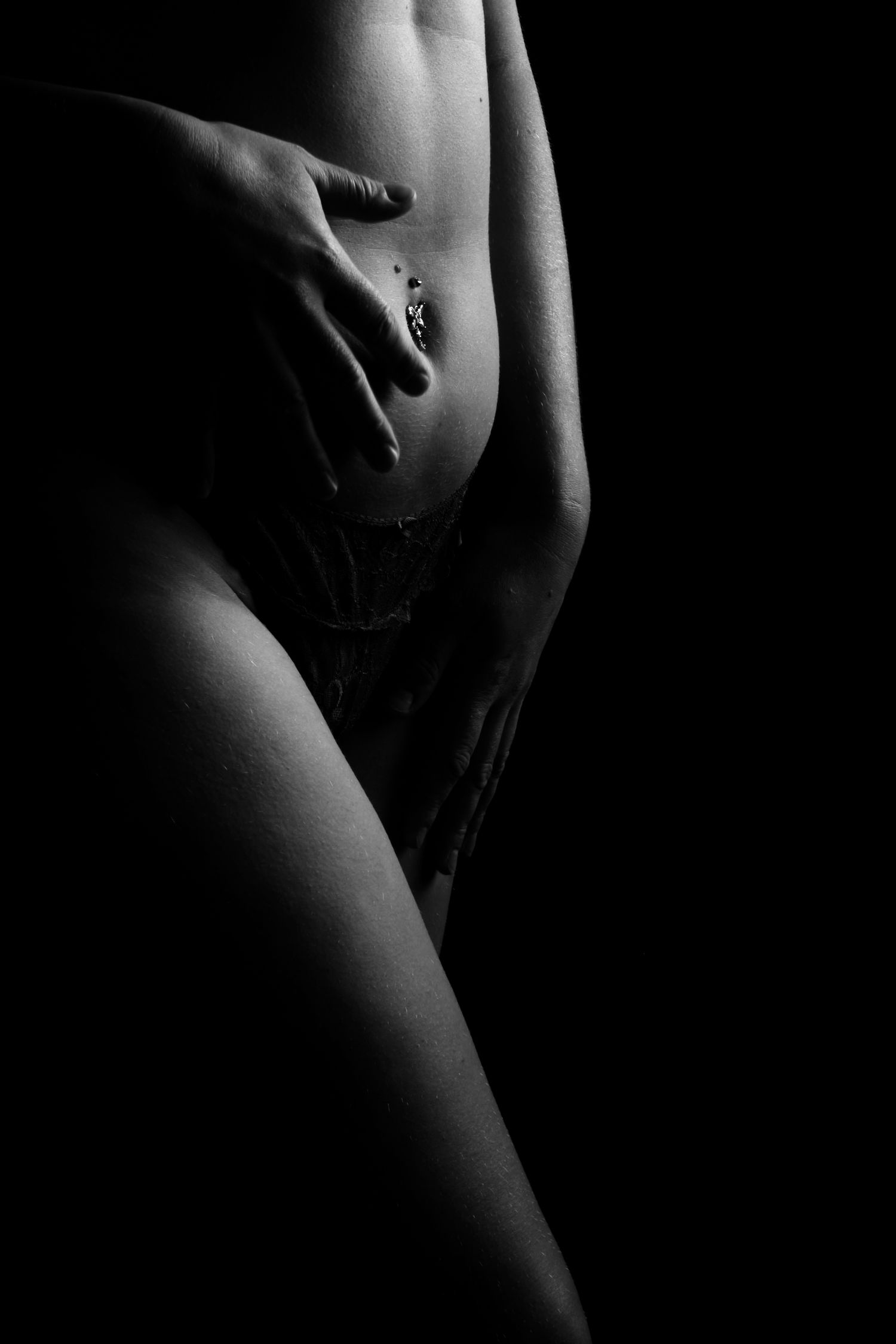 Black and white boudoir image of a woman's belly showing the skin with beautiful lighting in Ross on wye