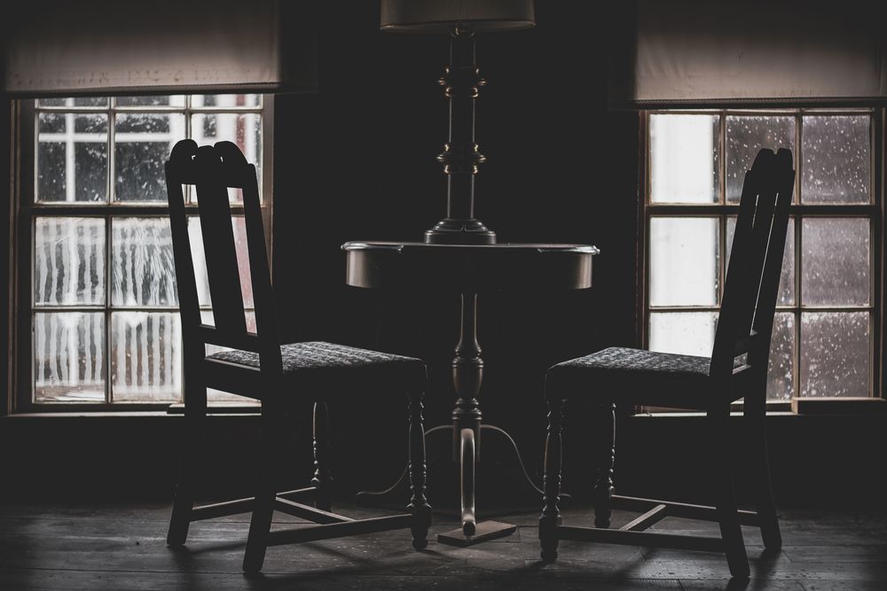 Dark and moody interior photographs of vintage rooms with windows showing black and white architectural details.