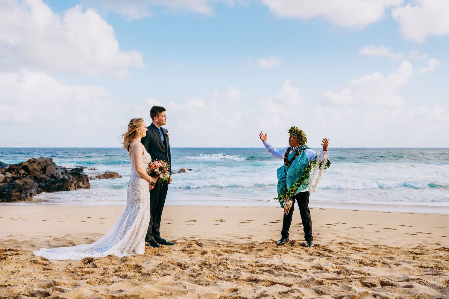 Beach wedding ceremony captured from a distance showing guests and ocean landscape.  Maui Hawaii wailea kihei makena beach wedding ceremony