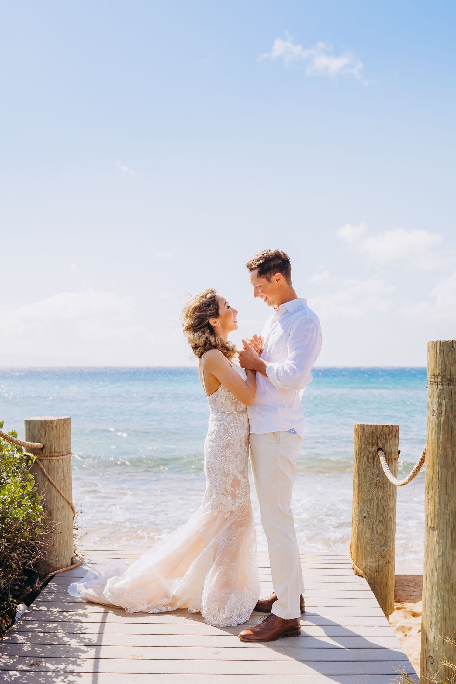 Romantic wedding couple poses on a wooden dock overlooking turquoise ocean waters. Maui Hawaii kaanapali sheraton duke's hawaii photography