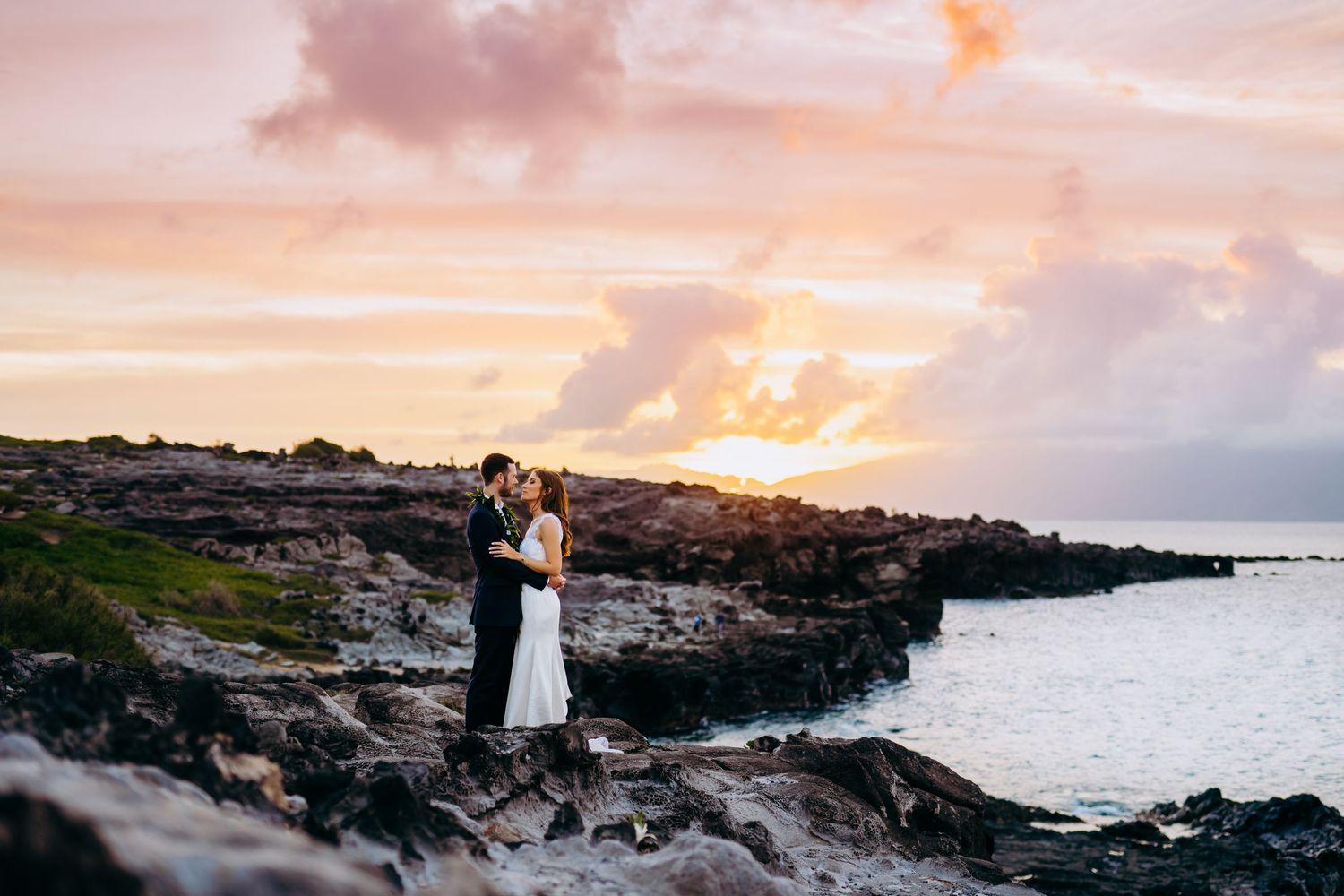 Dramatic coastal wedding photoshoot during sunset against rocky Hawaiian cliffs. Maui Hawaii Kaanapali Kapalua Merrimans wedding ironwoods