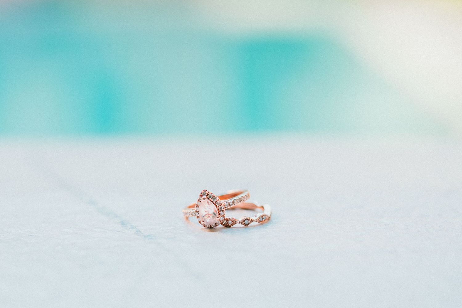 Delicate rose gold wedding rings displayed on light blue textured background. Maui Hawaii Ohau Hawaii Honolulu Cafe Julia Wedding