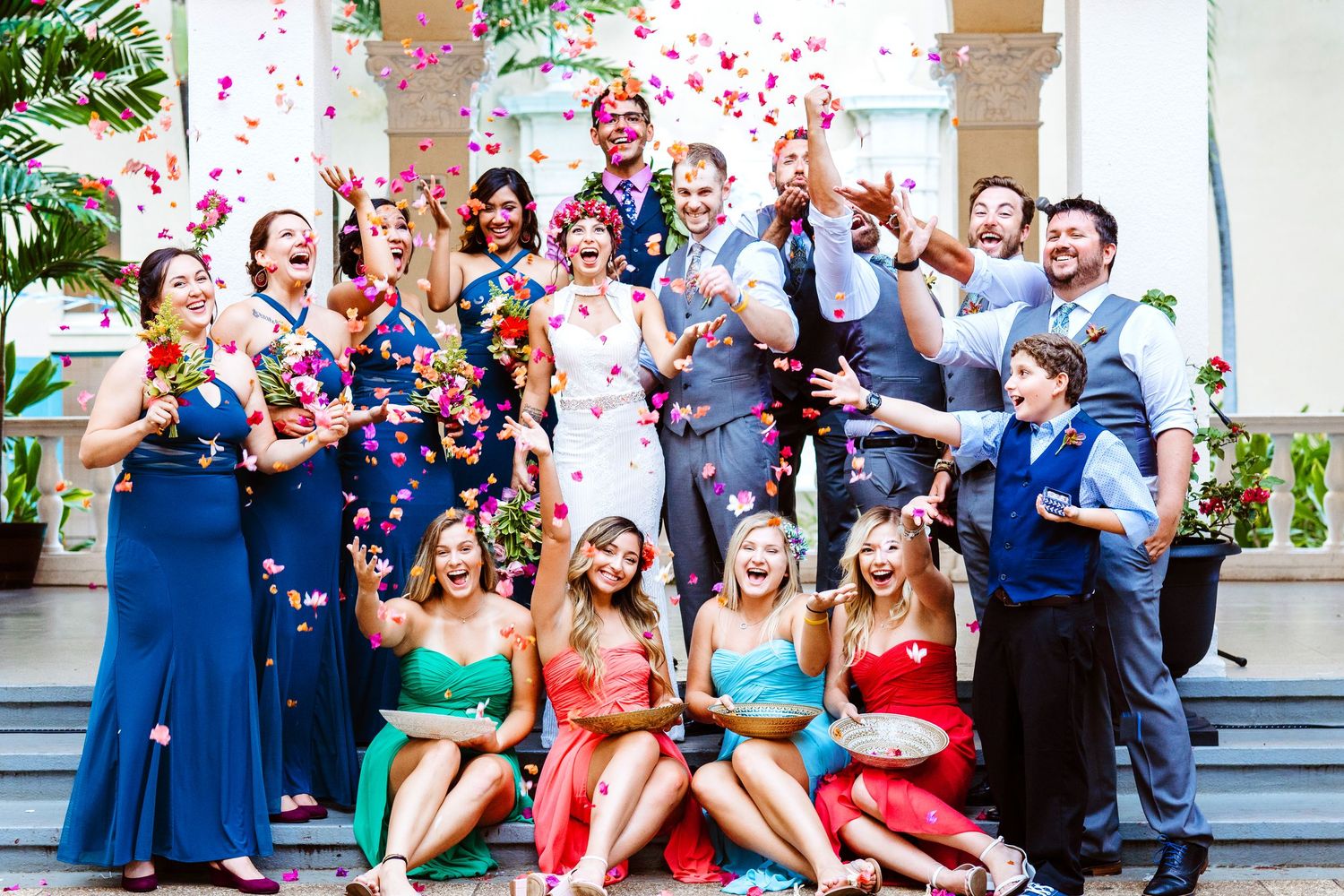 Wedding party guests celebrating with confetti in front of a white building. Maui Hawaii Ohau Hawaii Honolulu Cafe Julia Wedding