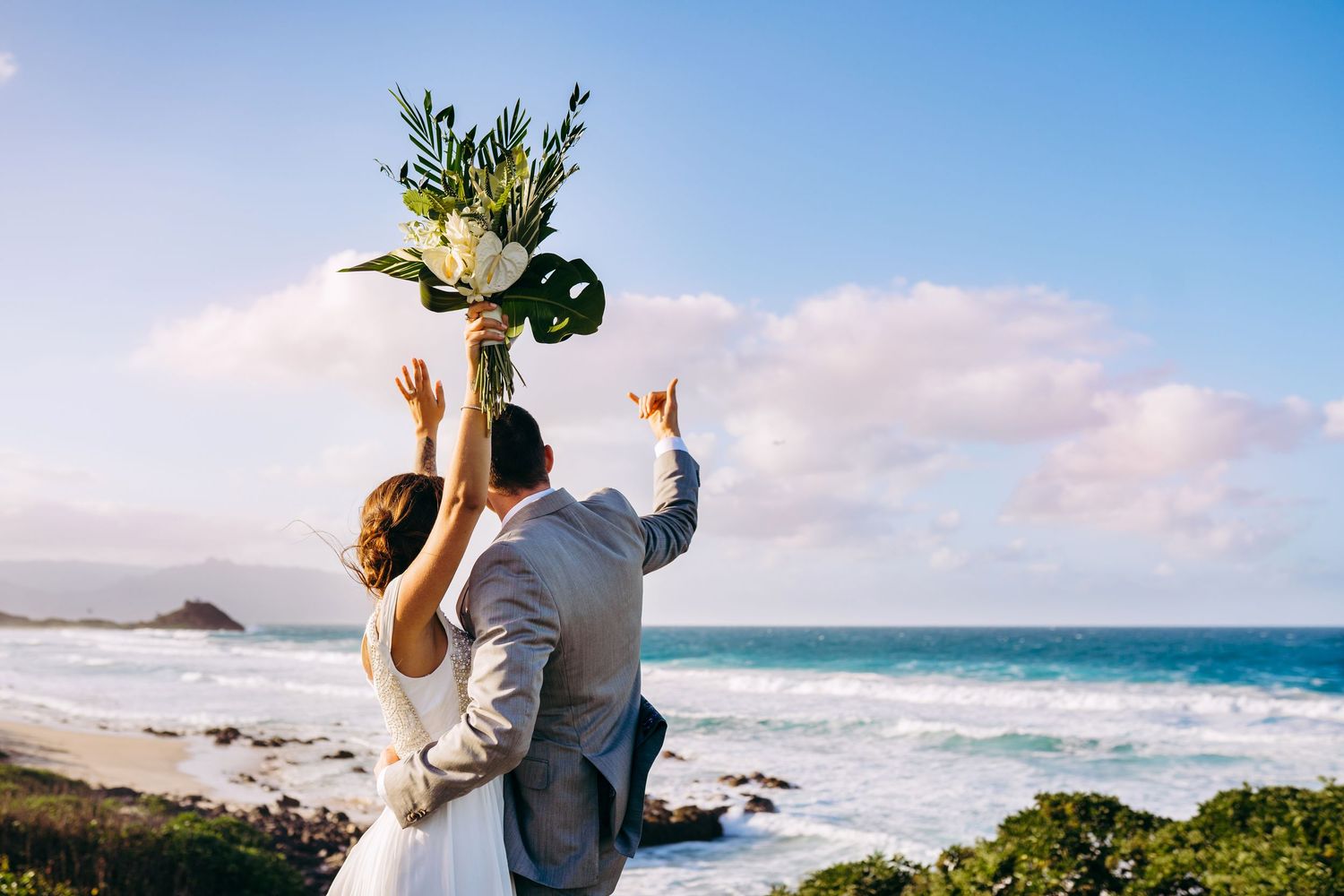 Scenic beach wedding photography session with ocean waves and palm trees in the background. Maui Hawaii Oahu Kaneohe Bay beach wedding