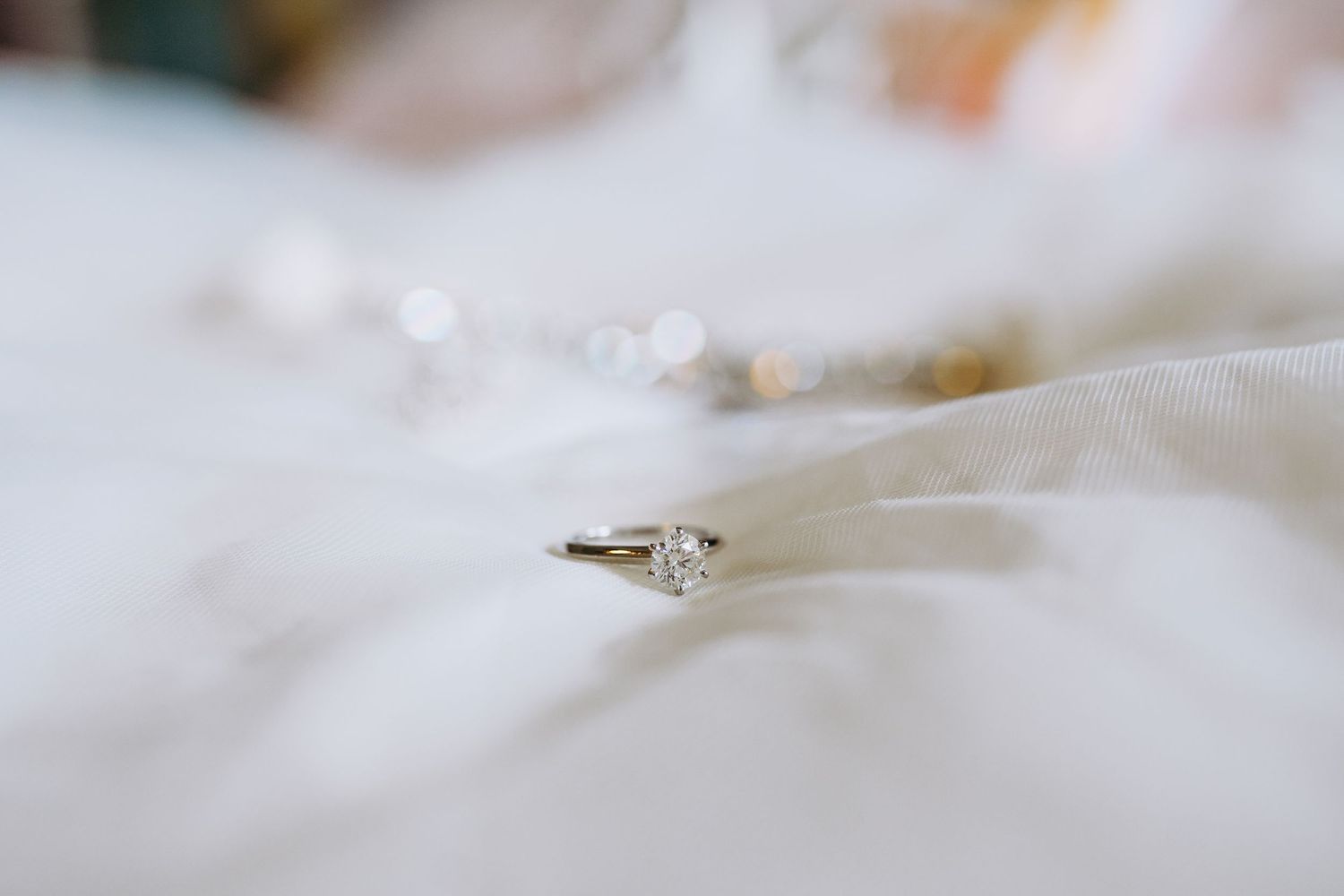 Close up macro shot of diamond engagement ring on white surface. Maui Hawaii Wailea Kihei Gather on Maui wedding photography ceremony