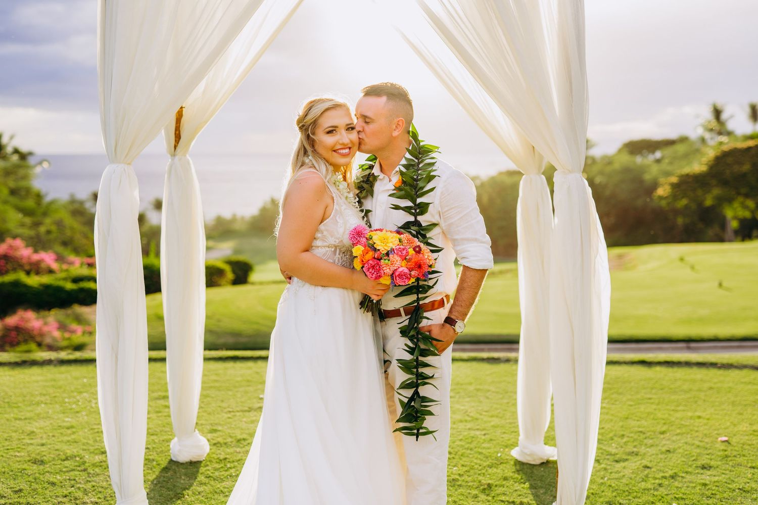 Wedding ceremony setup with white fabric draped arch on green lawn. Maui Hawaii Wailea Kihei Gather on Maui wedding photography ceremony