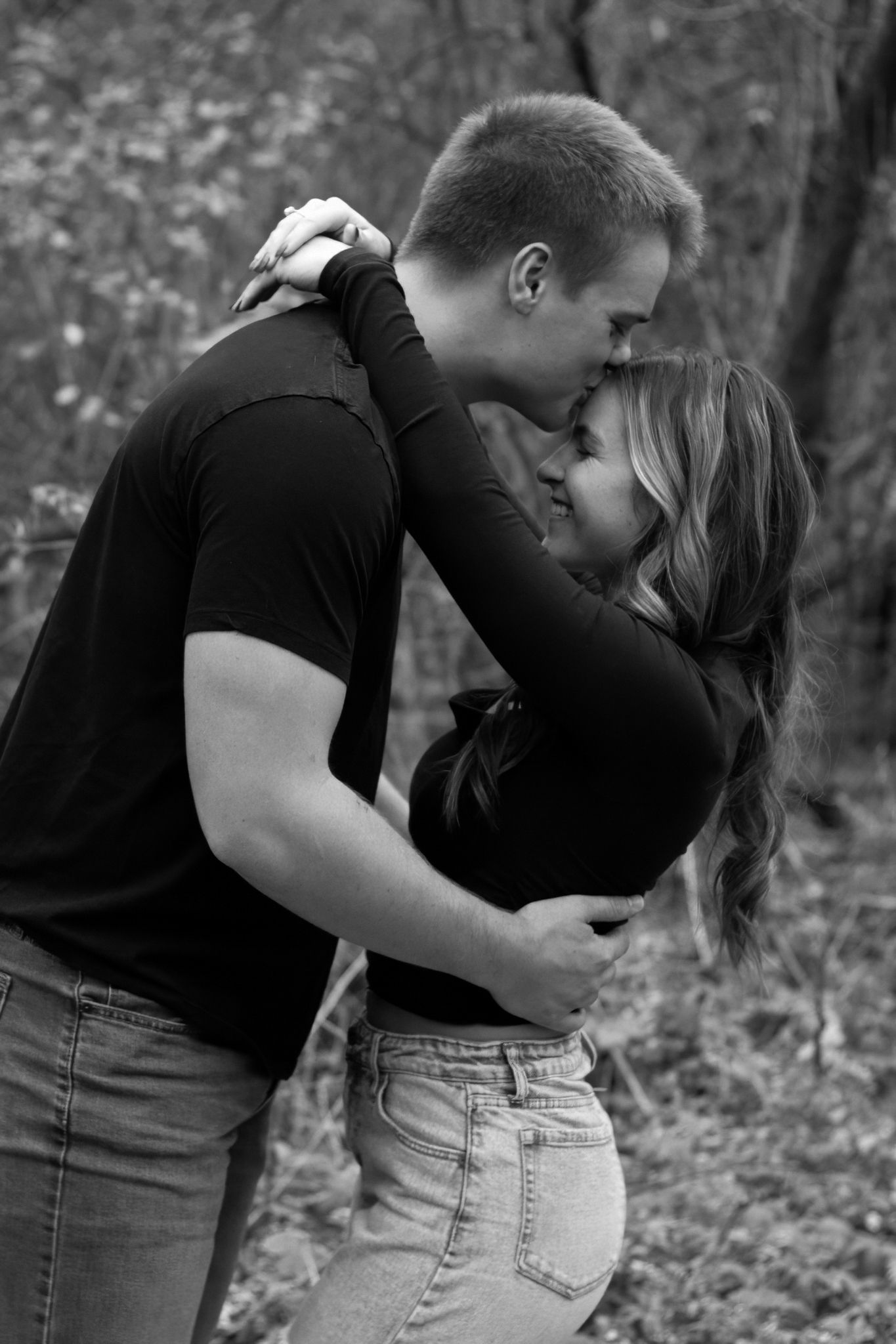 Black and white intimate portrait of couple embracing outdoors.
