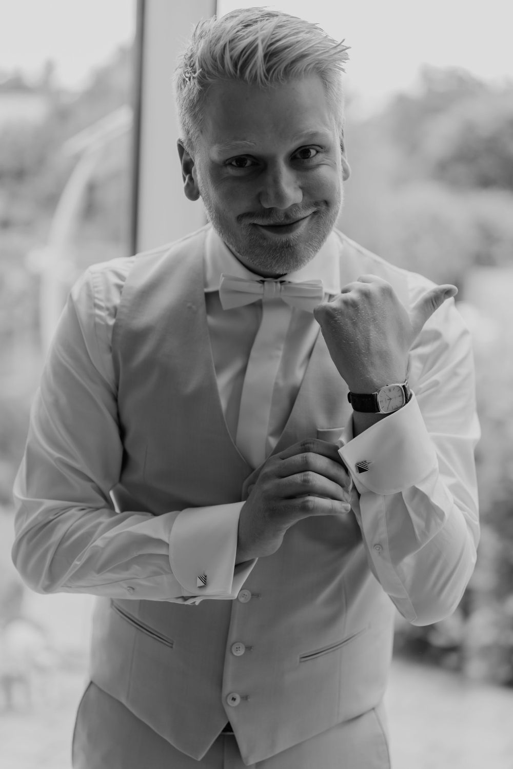 Wedding day preparation portrait in classic white bow tie and vest.