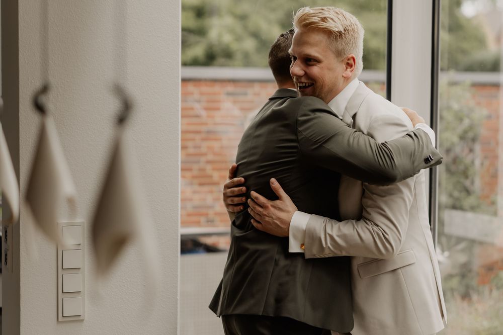 Emotional embrace shared between two people in formal wedding attire.