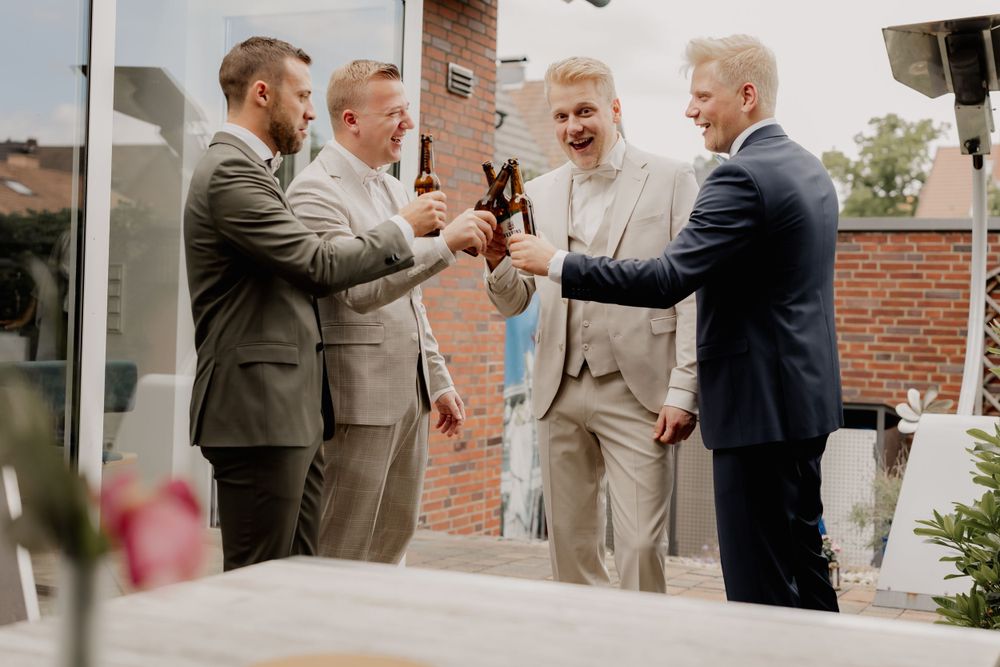 Wedding celebration toast with champagne glasses between formally dressed guests outdoors.