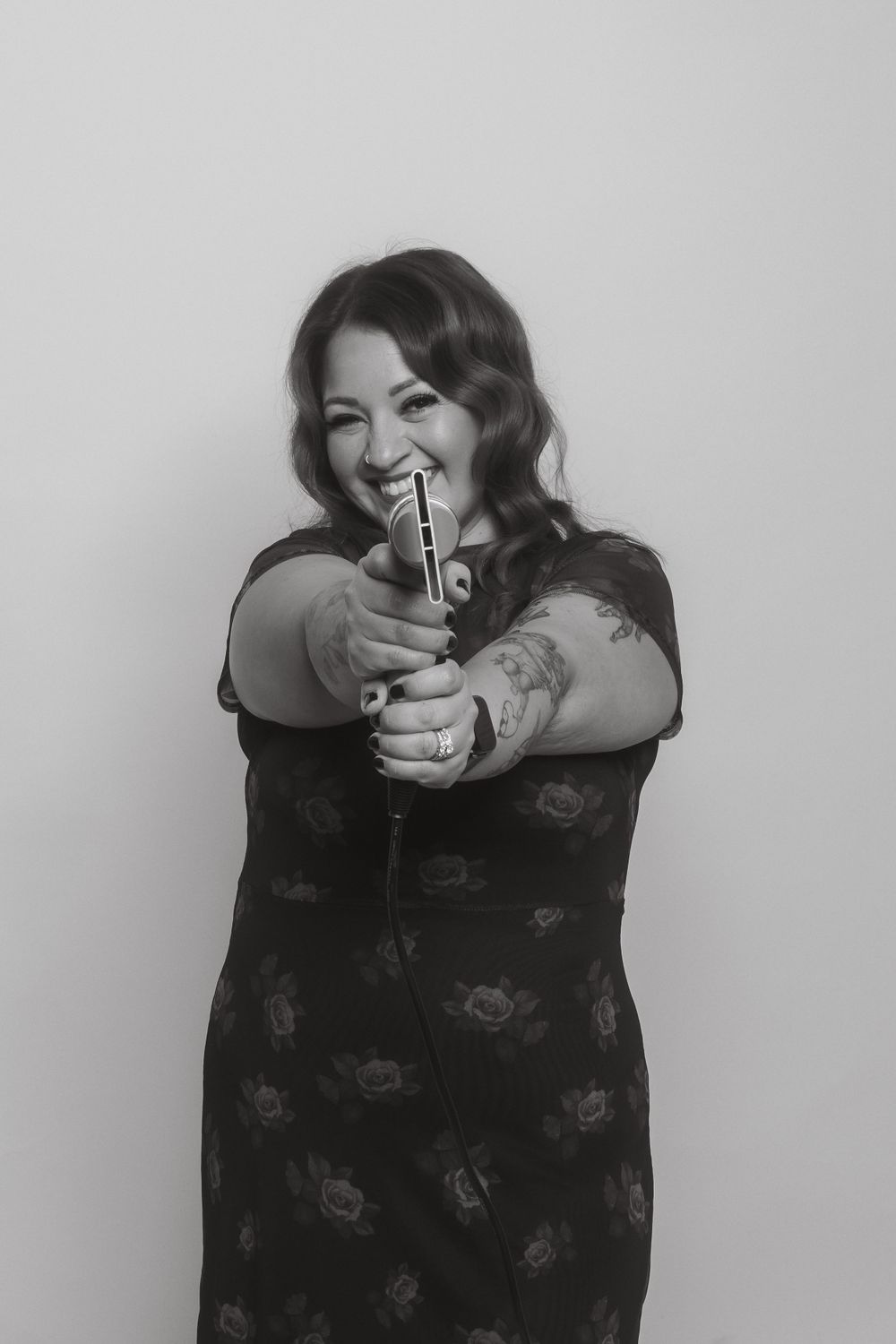 Playful black and white portrait showing someone holding a styling tool with enthusiasm.