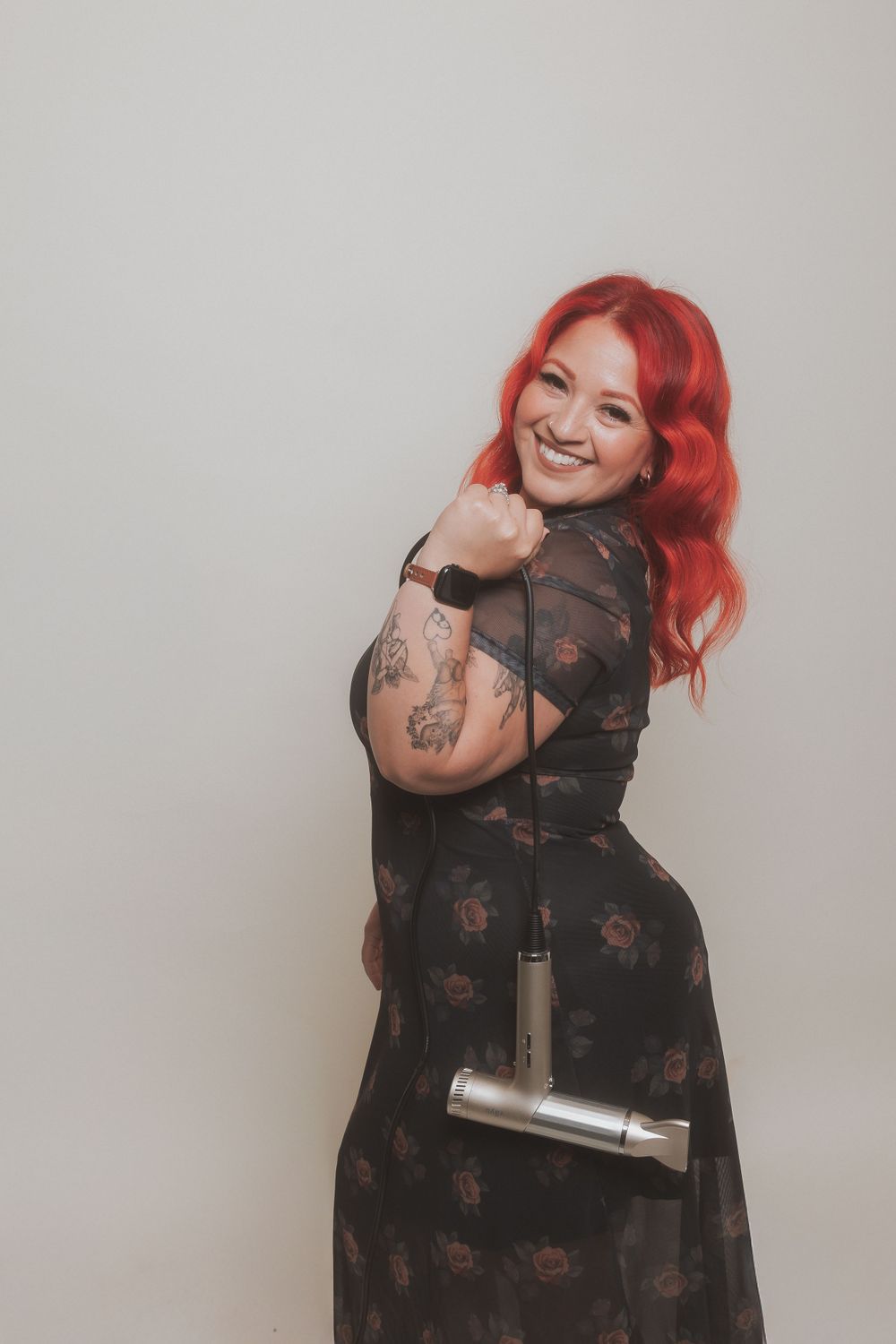 Lifestyle portrait showing joyful pose with professional hair styling tool.