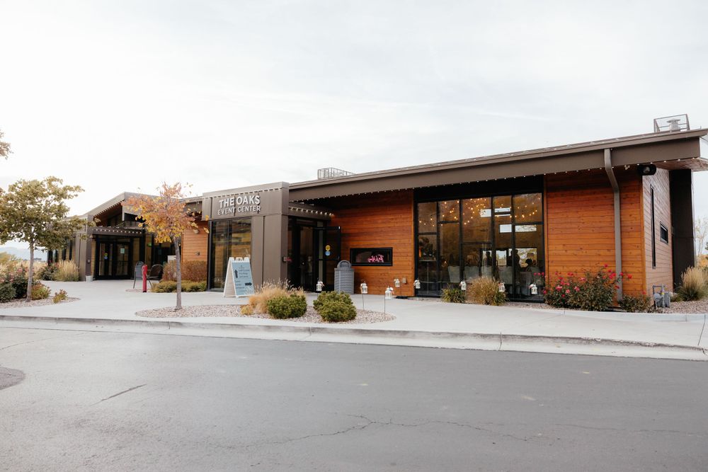 Modern rustic wedding venue exterior featuring wood and stone architecture with landscaped surroundings.