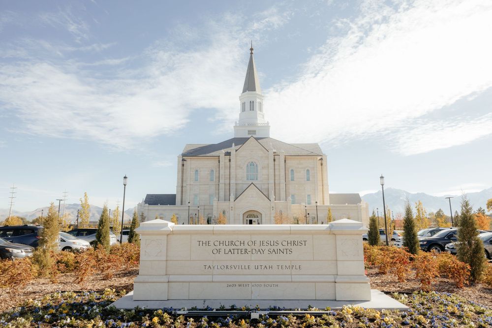 The Church of Jesus Christ of Latter-day Saints Orem Utah Temple with white steeple and autumn foliage.