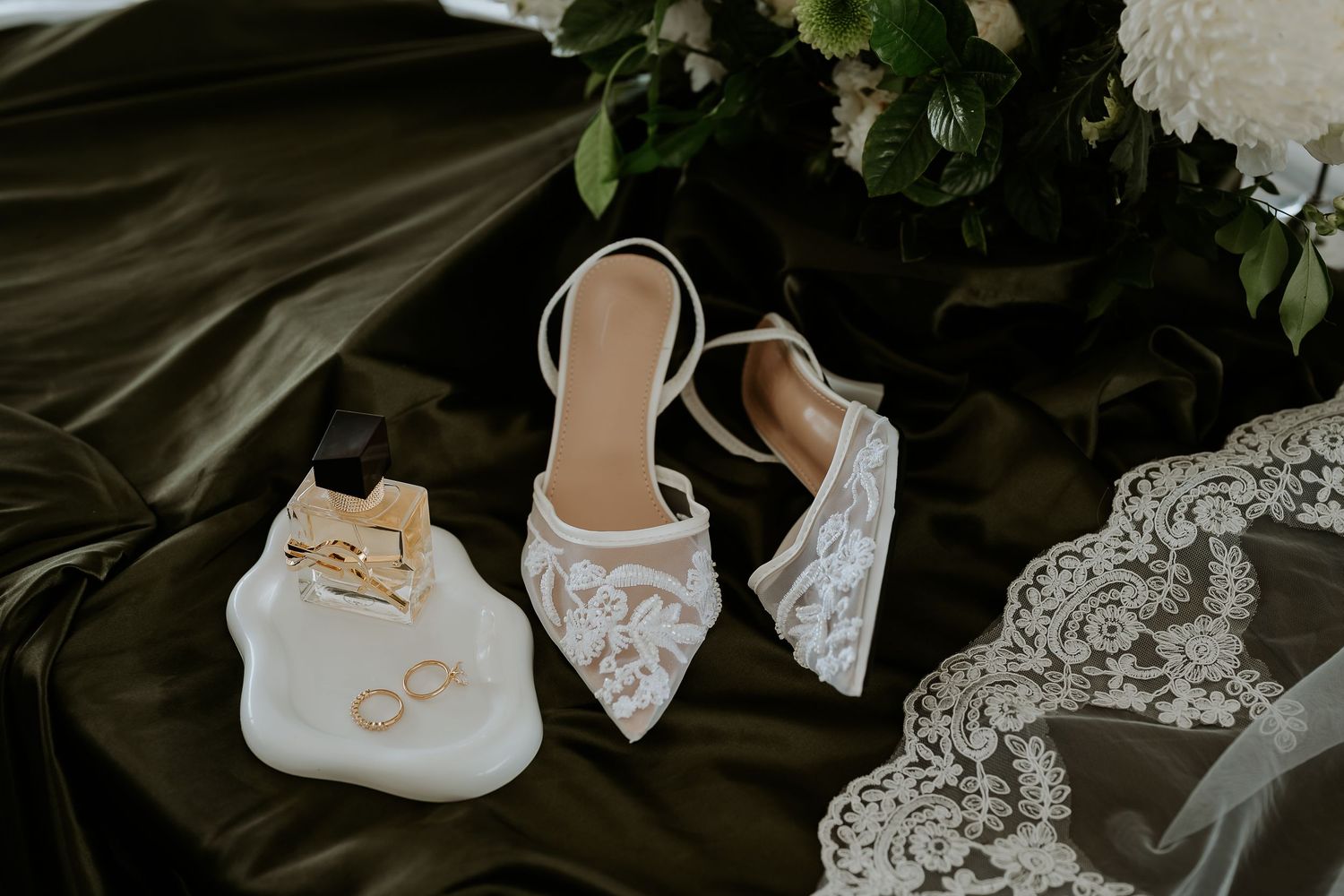 Wedding detail photos including rings, shoes, lace, and floral elements arranged on dark background.