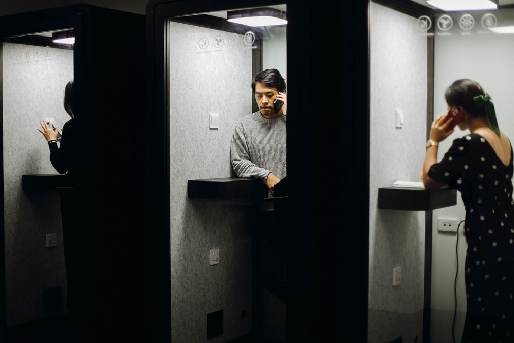 Split view of three people in separate elevator spaces in a modern building.