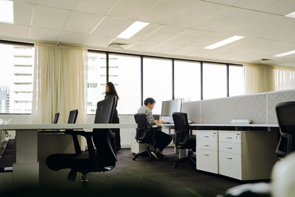 Minimalist open office workspace with desks and natural lighting.