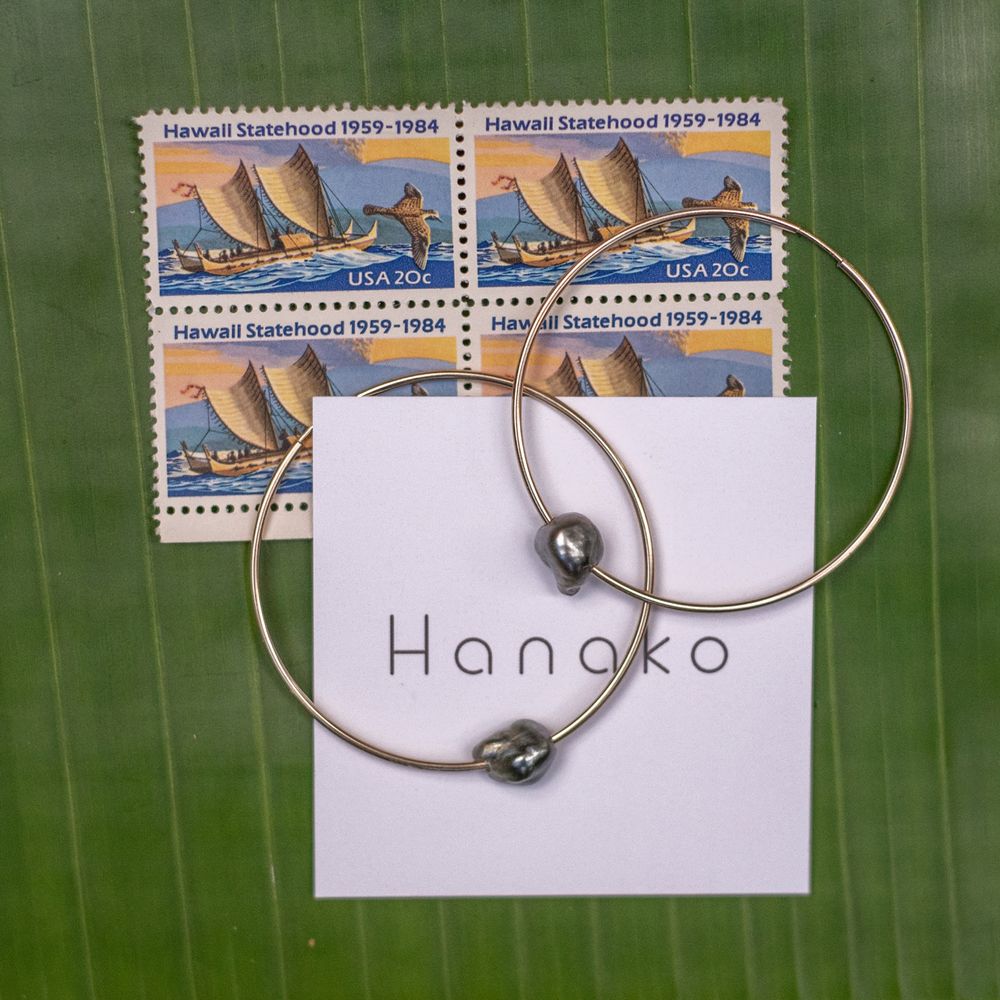 Vintage sailing stamps and silver jewelry displayed with Hanako branding on green leaf background.