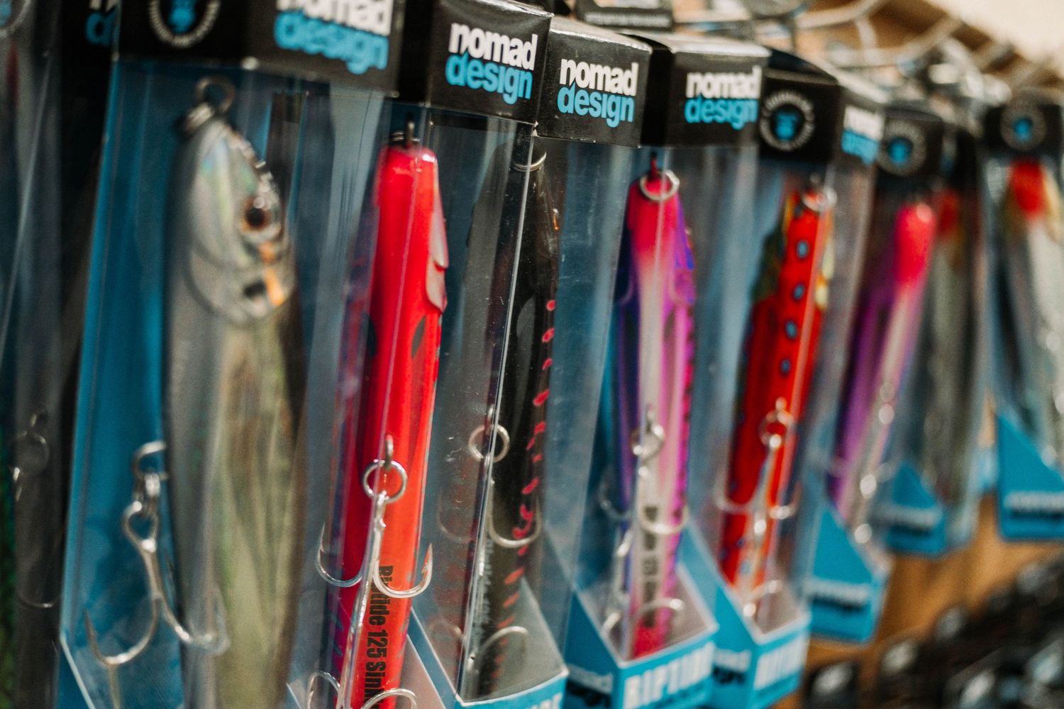 Display rack of colorful fishing lures hanging in retail setting.