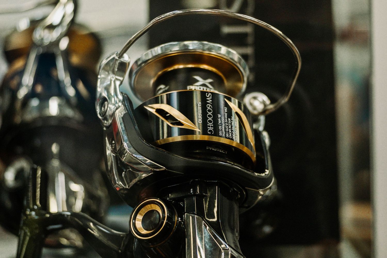 Close-up of a black fishing reel showing intricate mechanical details.