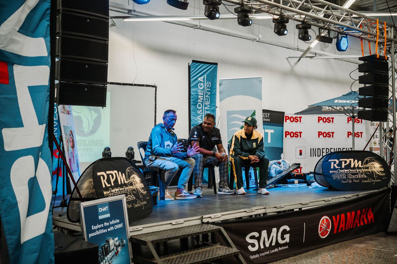 Panel discussion setup on stage with speakers and audio equipment at fishing event.