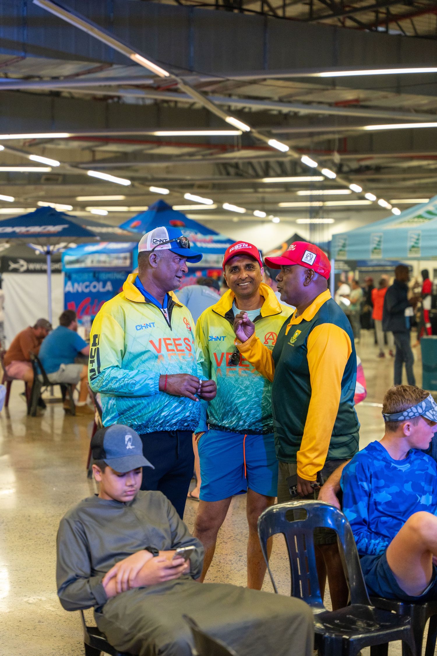 Participants in colorful jackets gathered at an indoor sporting event venue.
