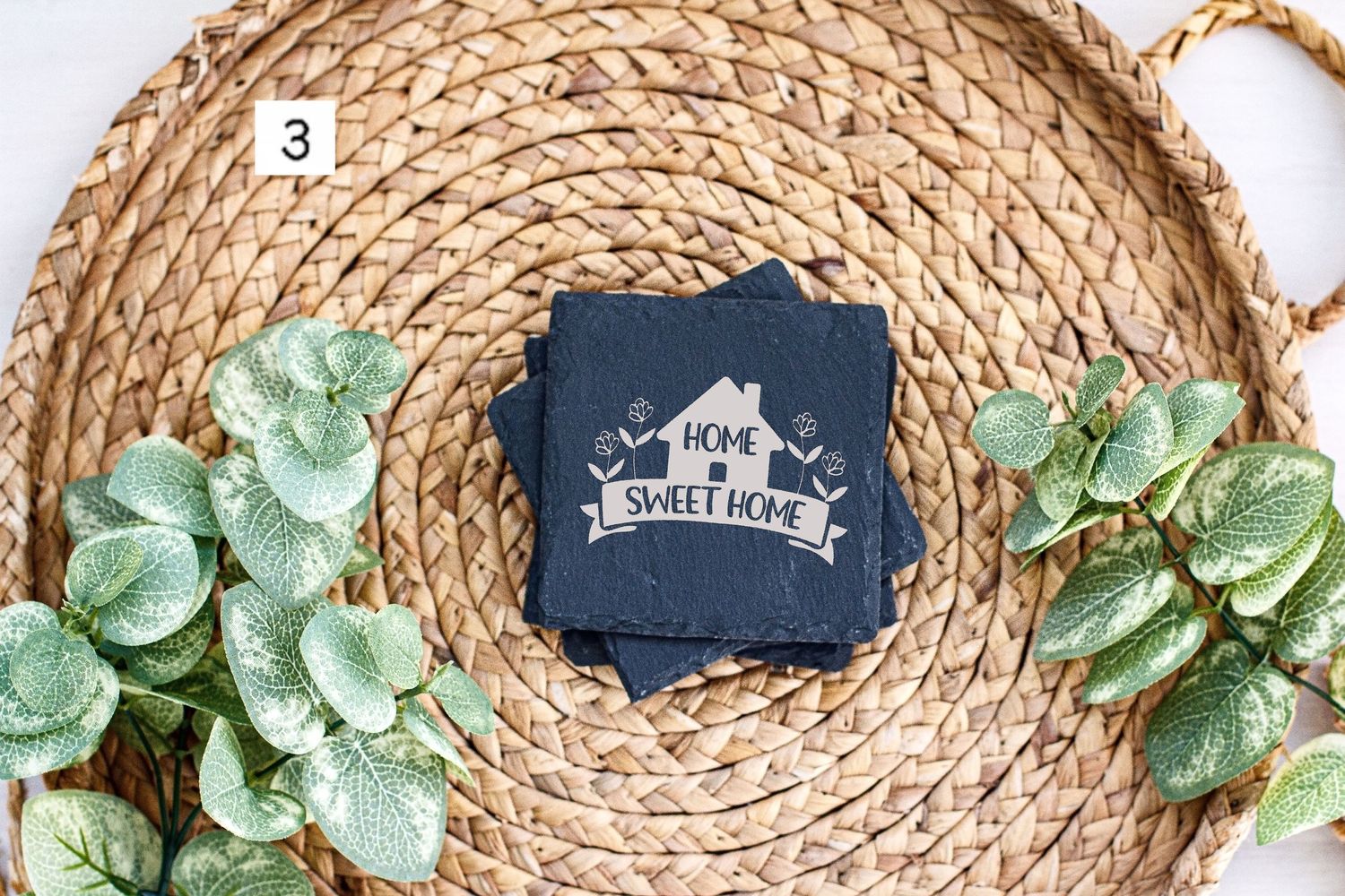 Dark blue tag with house banner design displayed on circular woven mat with green leaf accents.