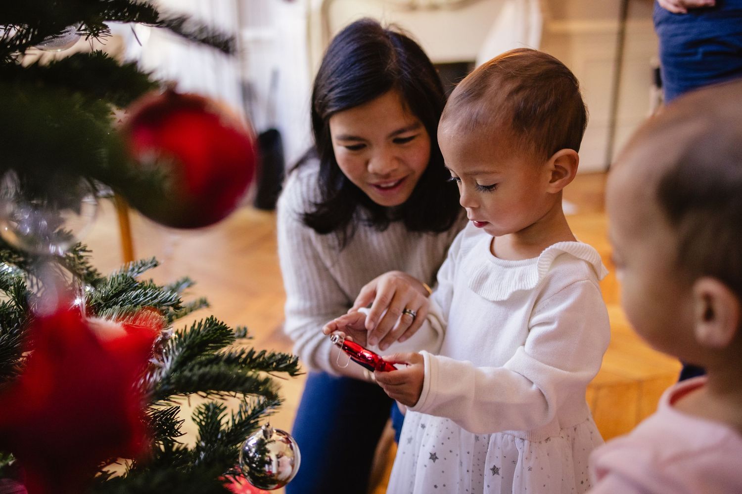 Séance photo offerte comme cadeau de noël avec des jumelles admirant les décorations du sapin