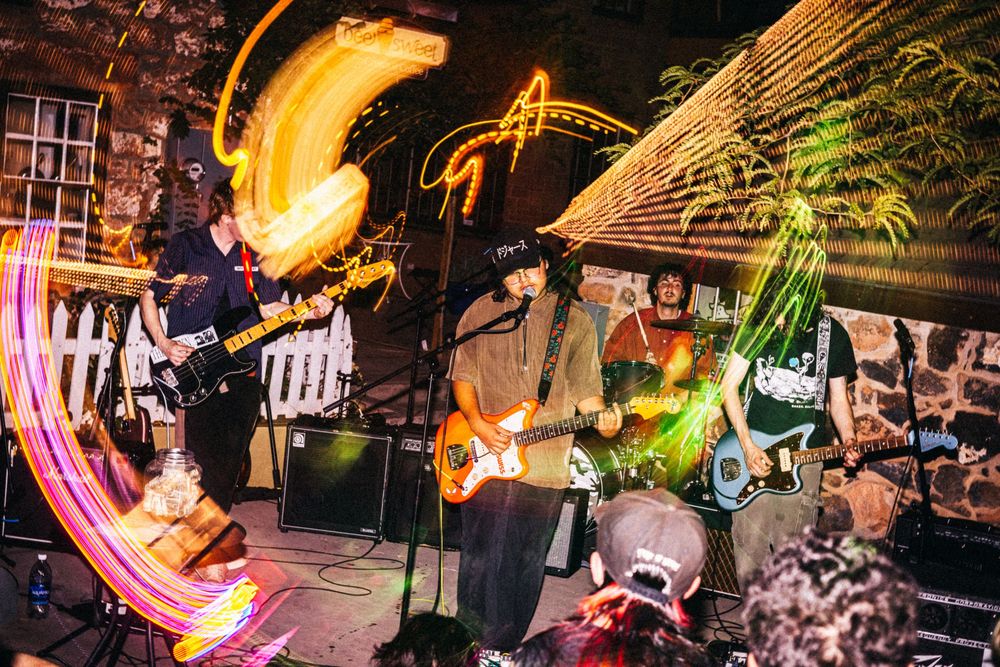 Fire performers create dazzling light trails during a nighttime show at an outdoor venue.