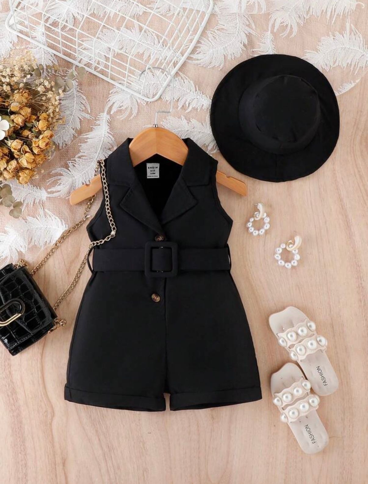 Black formal vest collection with accessories displayed on beige background.