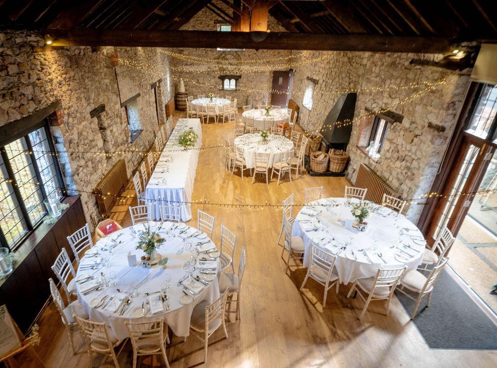 Rustic stone wedding venue interior set up with round tables and elegant decor.