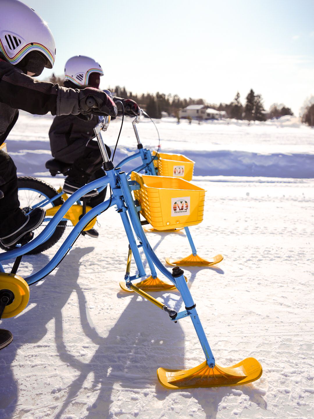 Blue and yellow snow bike performing tricks and jumps on a snow-covered terrain.