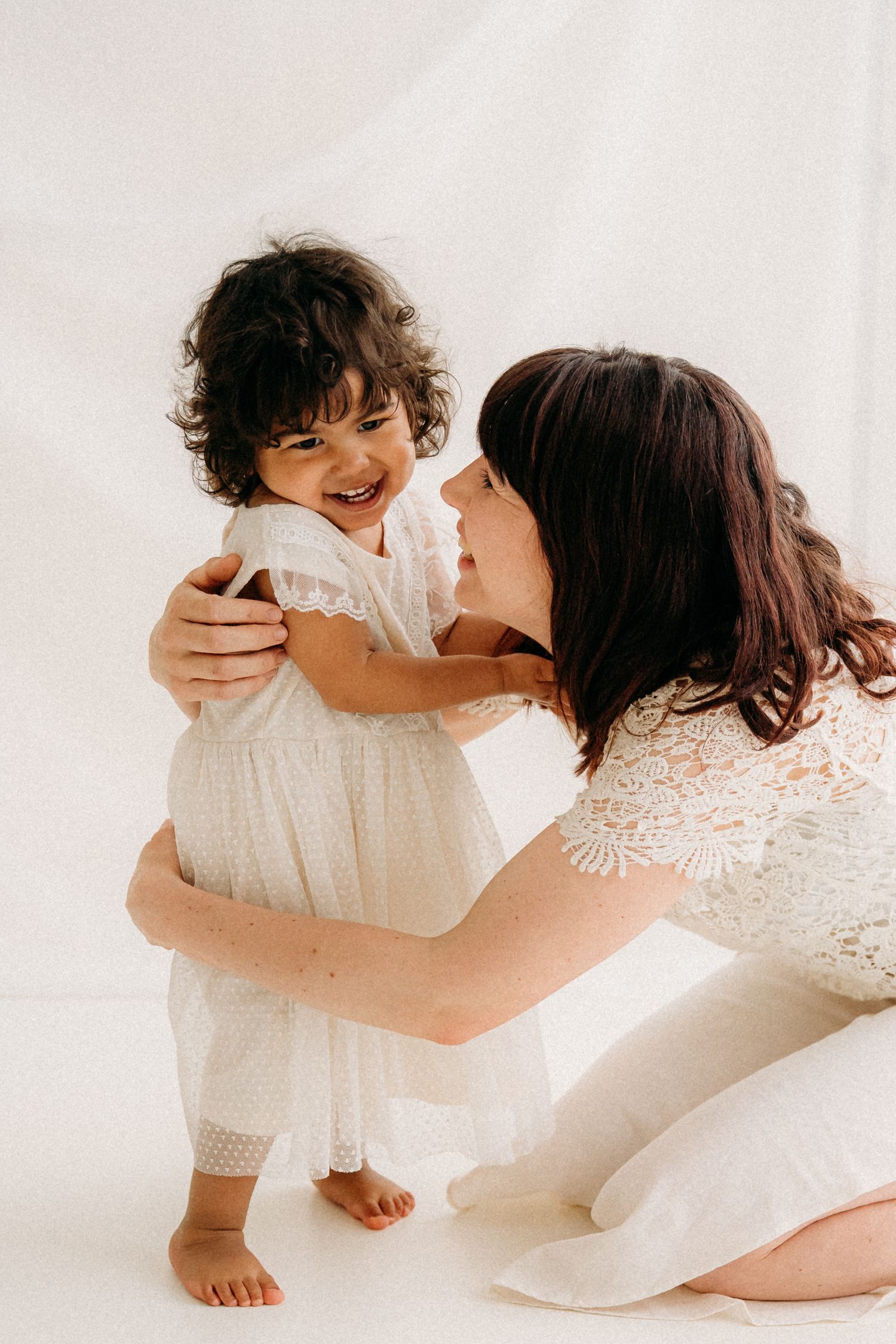 Zachte knuffels tussen mama en haar kindje, vastgelegd tijdens een tijdloze mommy & me fotoshoot in Antwerpen.