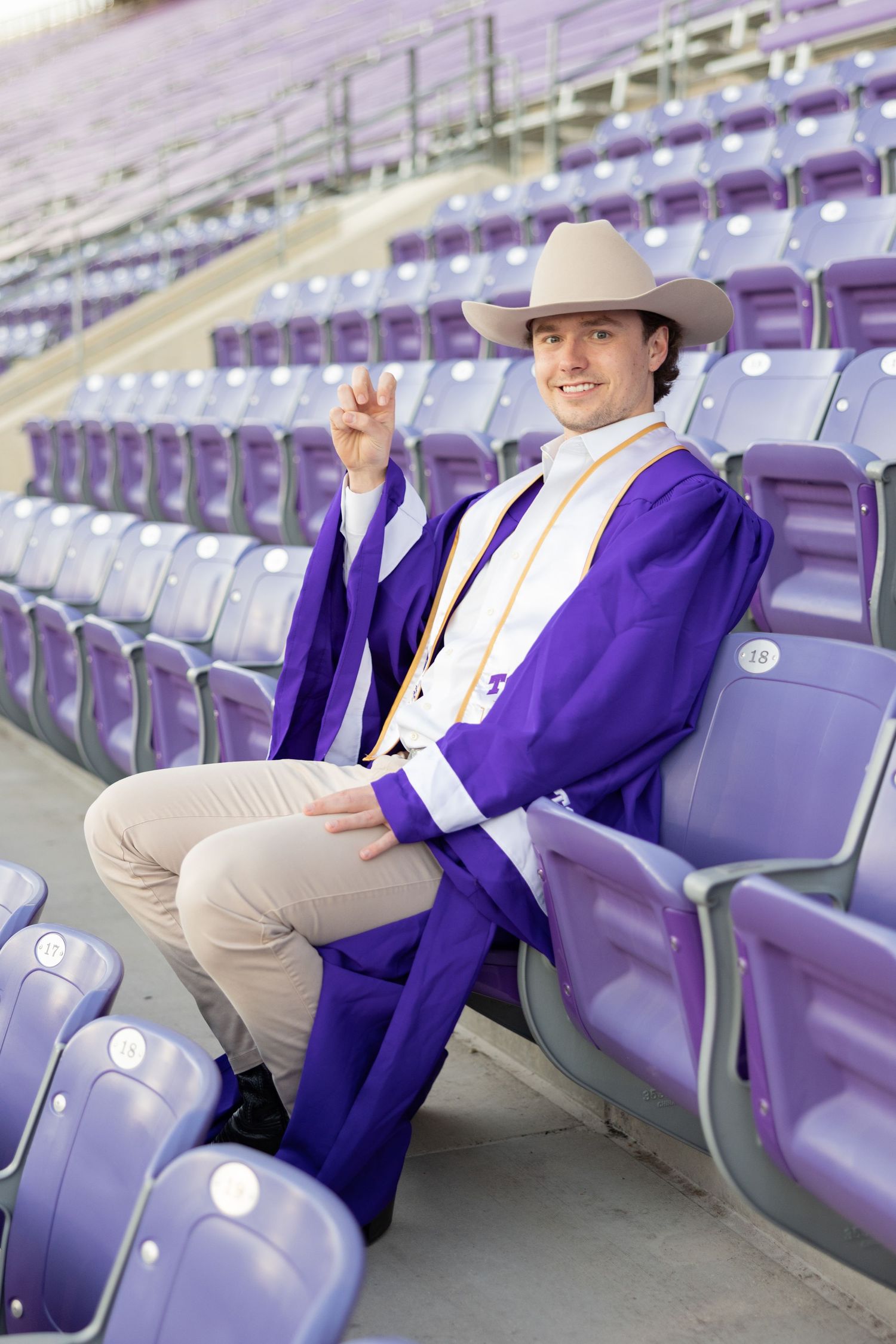 Senior photographer taking photos of senior guy at Texas Christian University in Fort Worth Texas.
