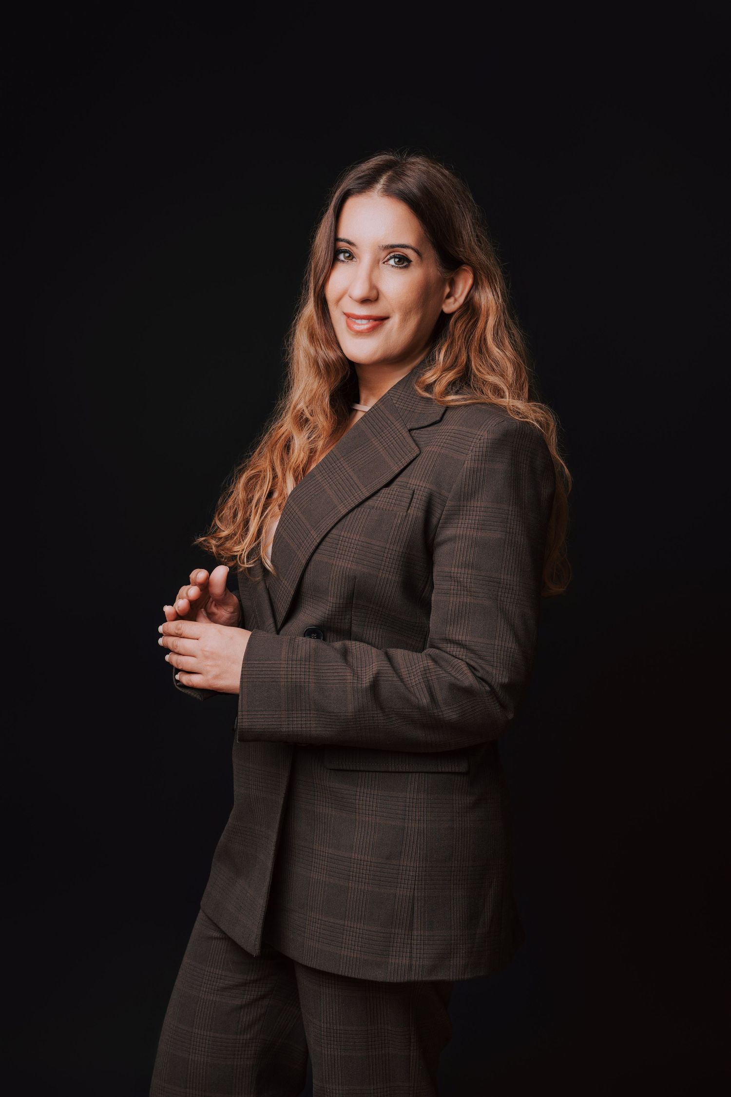 Professional studio portrait series showing a person in a brown plaid blazer against a dark background.