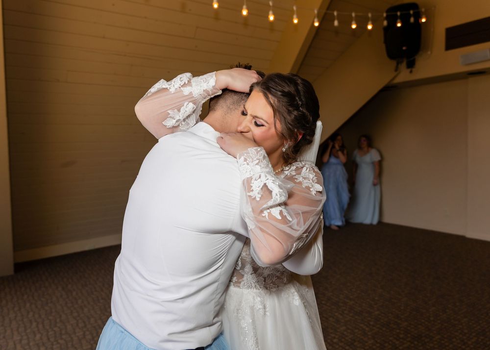 Bride and groom share a romantic first dance kiss at their wedding reception in an elegant venue.