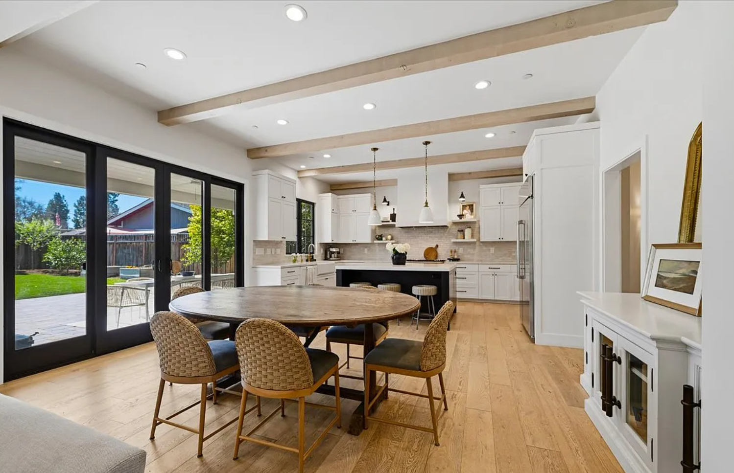 Modern open concept home interior with light hardwood floors and recessed lighting showcases seamless design flow.