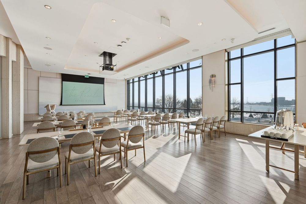 Sunlit dining hall with contemporary furniture and floor-to-ceiling windows offering panoramic views.