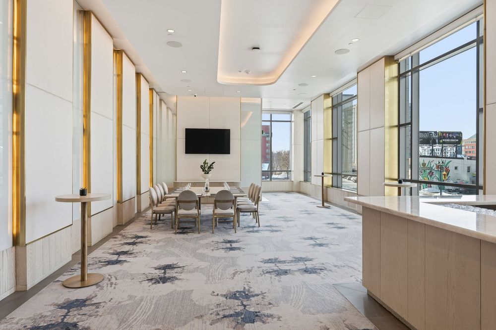 Modern office interior with glass walls, wood accents, and recessed lighting creates an open, contemporary workspace.