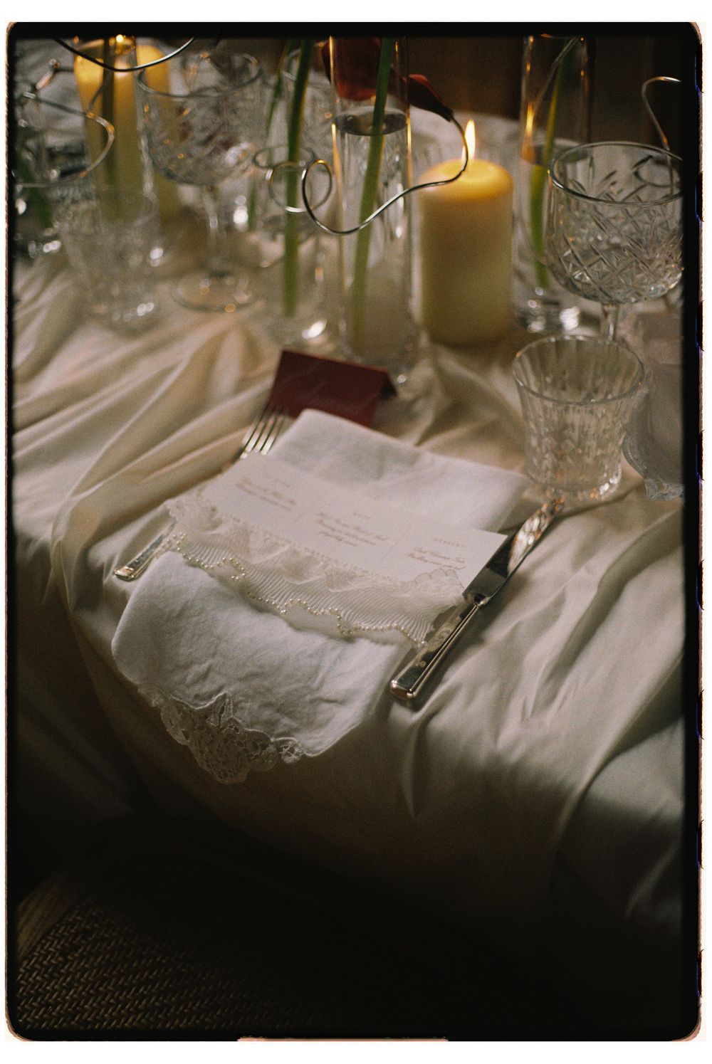 Elegant table setting with white linens, crystal glassware, and menu cards for a formal dining event.