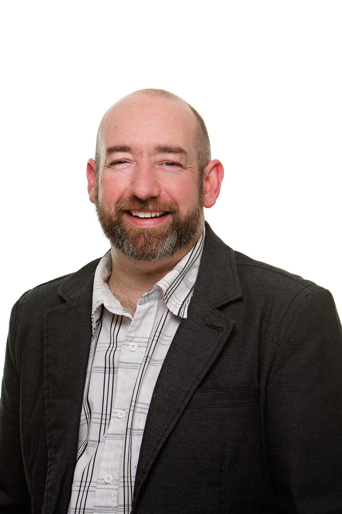 Professional headshot series showing different expressions in black suit and striped shirt against white background.