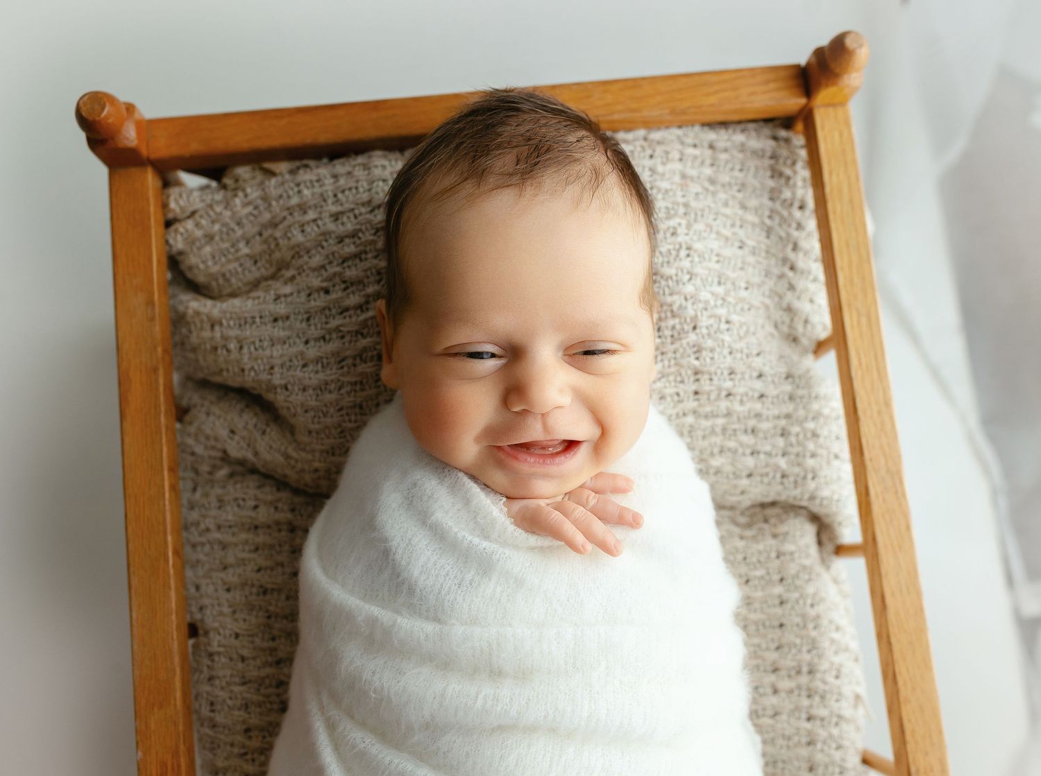 Newborn boy in a cradle smiling. - Greenville, SC newborn photographer - Easley, SC newborn photographer.