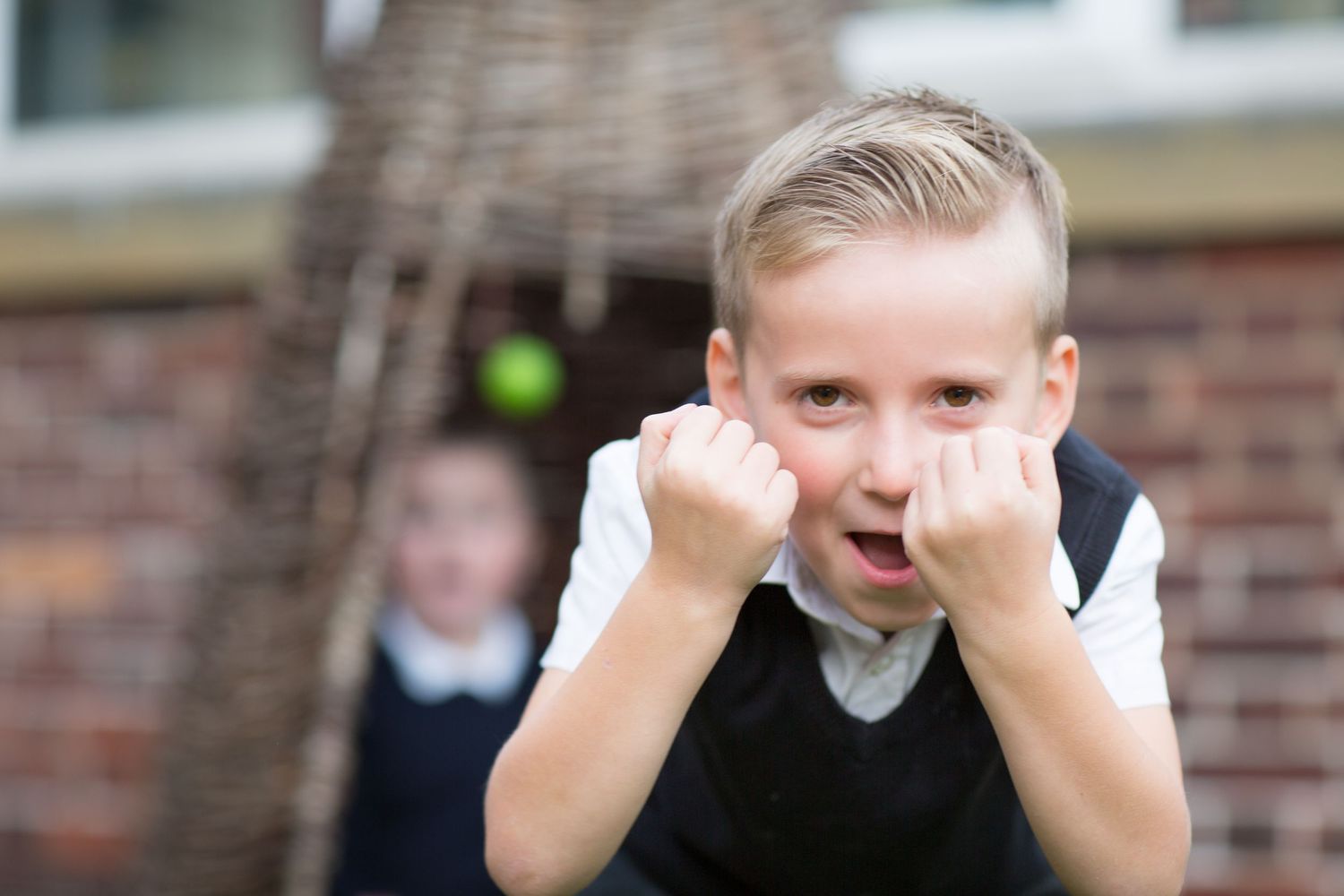 Collage of four photos showing a person making different facial expressions and gestures against a brick wall background.