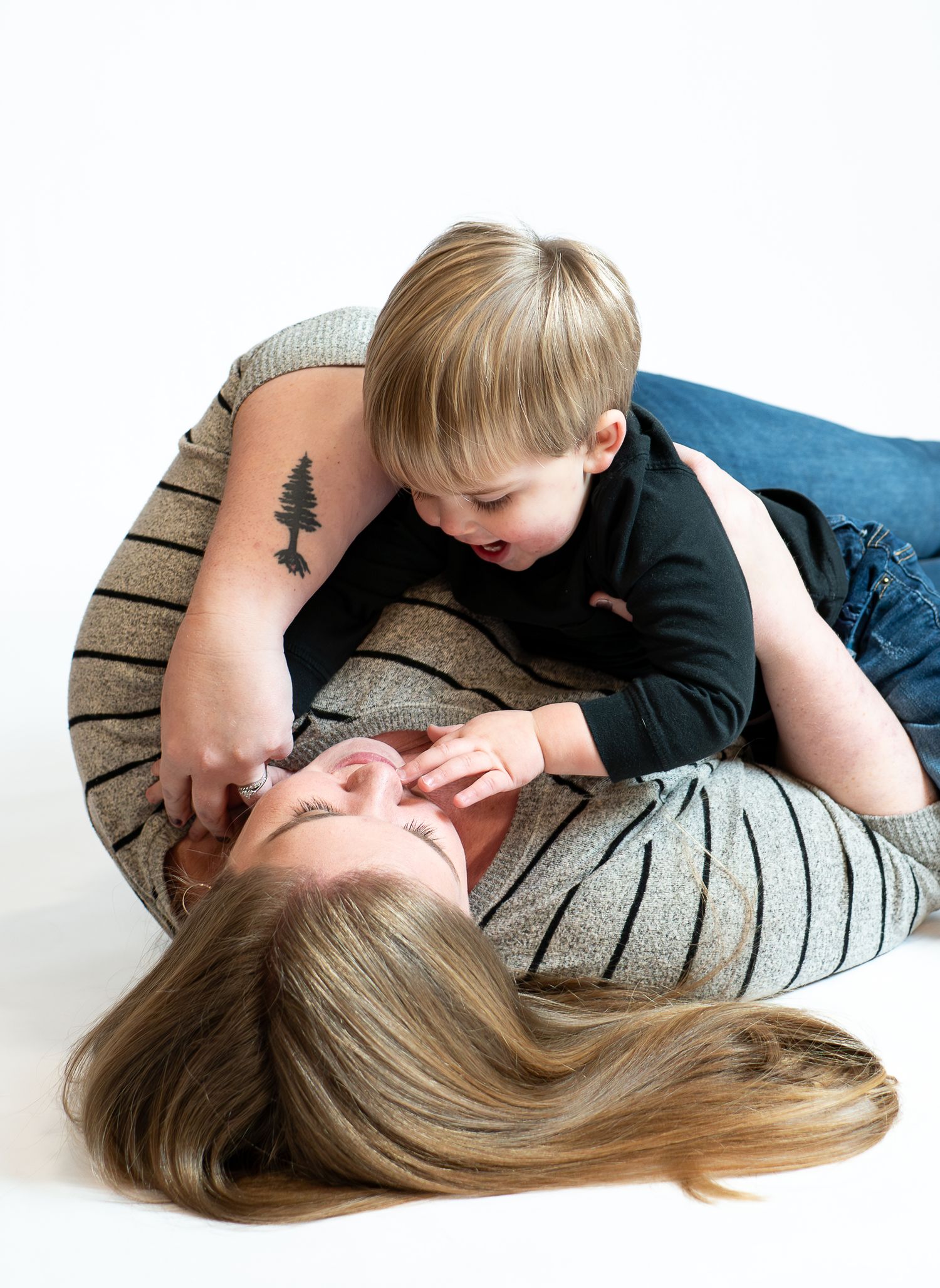 Two people share a tender moment lying down together on a striped couch in a series of intimate poses.