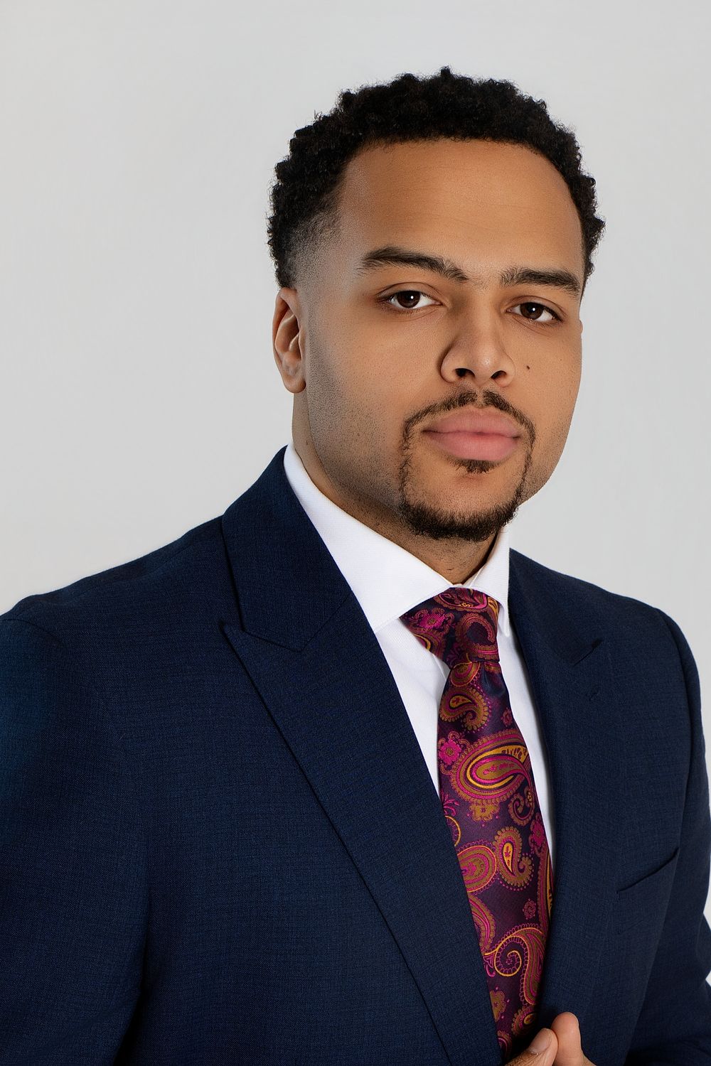 Business portraits featuring someone in a navy suit with burgundy patterned tie.