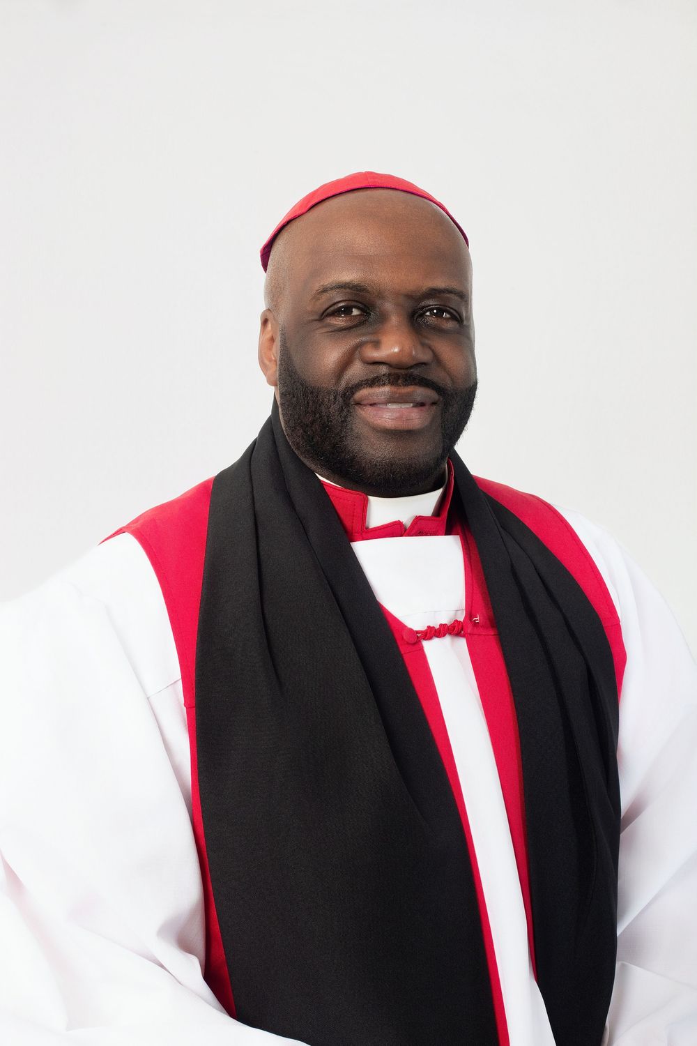 Portrait series of someone in religious attire with white robe, red cap, and black scarf.